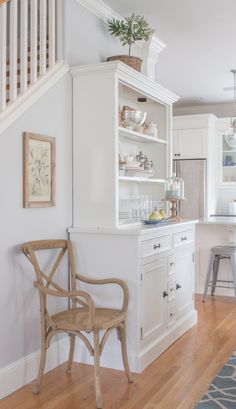 a kitchen with white cabinets and wooden floors