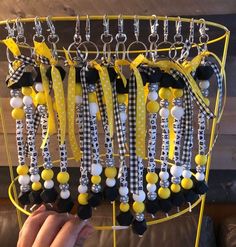 a person holding up a rack with many necklaces on it