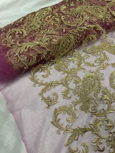 two different types of fabric on top of each other, one with gold and purple designs