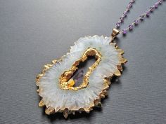 This listing is for one White Quartz and Amethyst Necklace. This stunning piece is absolutely HUGE!This necklace is electroplated in gold and comes on a 30 inch wire wrapped amethyst and gold plated chain with a small accent amethyst crystal in the middle of the pendant.Pendant size with bail: 90mmx60mm ( 3 1/2 inches x 2 3/8 inches )I ship all additional items for free as long as they are paid for on the same invoice.Please check out my other listings for more Necklaces :https://www.etsy.com/sh Gold Crystal Necklace With Gemstone Accents For Healing, Gold Amethyst Jewelry With Stones, Unique Gold Amethyst Jewelry, Unique Amethyst Gold Jewelry, Gold Amethyst Jewelry With Gemstone Beads, Gold Amethyst Necklace With Gemstone Beads, Amethyst Gold Jewelry With Gemstone Beads, Gold Amethyst Crystal Necklace With Natural Stones, Unique Gold Crystal Necklaces With Stones