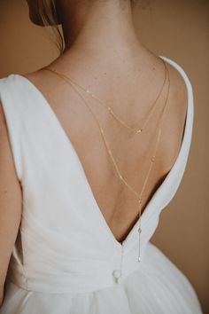 Elara Backdrop Necklace Perfect for any bridal gown with a plunging back, our Elara Back Necklace features petite marquise crystals that elegantly drape across your back. This back-drop necklace is the perfect keepsake.  Available in Gold. Dimensions: Chain drops 13.5" down the back. Our earrings, necklaces and bracelets are lead, nickel and cadmium free. These pieces are hypo-allergenic and are safe for sensitive skin and ears. Each order is thoughtfully gift wrapped and shipped in a gold embos Bride Back Necklace, Bridal Drop Necklace, Elegant Gold Backdrop Necklace For Bride, Elegant Backless Backdrop Necklace For Wedding, Delicate Teardrop Backdrop Necklace For Weddings, Elegant Drop Backdrop Necklace For Wedding, Wedding Backdrop Necklace With Delicate Teardrop Chain, Dainty Drop Backdrop Necklace For Wedding, Gold Teardrop Backdrop Necklace For Weddings