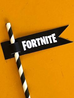 a black and white striped straw with the word fortnite written on it next to a sign that says fortnite