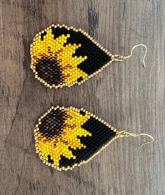 pair of yellow and black beaded earrings on wooden table