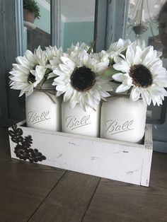 three white mason jars with sunflowers in them