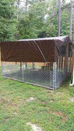 a dog kennel with a tarp over it