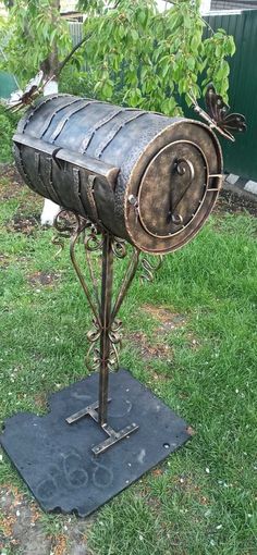 a metal mailbox sitting on top of a green field