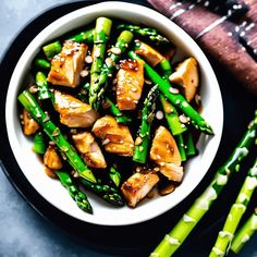 a white bowl filled with chicken and asparagus