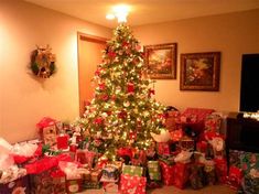 a christmas tree with presents under it in a living room