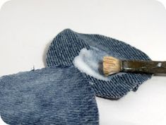 a pair of blue jeans with a paintbrush sticking out of it