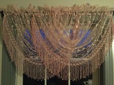 the curtains are hanging from the ceiling in the room, and it looks like they have beads on them