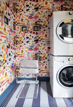 a washer and dryer in a room with colorful wall paper on the walls