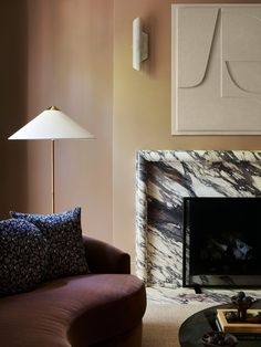 a living room with a couch, chair and fire place in front of a painting on the wall