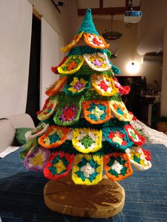 a crocheted christmas tree sitting on top of a blue tablecloth covered floor