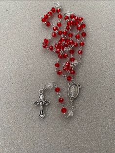 a rosary with red beads and a crucifix