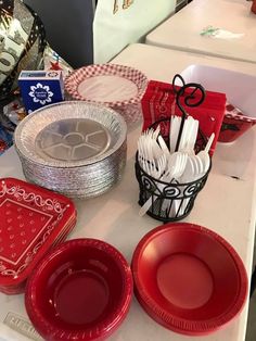 red plates and silverware on a table at a party or event with other items