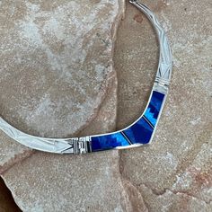 This gorgeous Sterling Silver Necklace, is from the Blue Sky Collection which features Royal Lapis, Denim Lapis and Cultured Opal in a Fancy Inlaid Pattern with detailed Sterling Silver Links. Dimensions: 19" Total Length; Centerpiece Link: 2 3/8"W x 1/2"H They are designed by David Rosales, one of the finest contemporary Southwest Artists. He is the founder and co-owner of Supersmiths, Inc. of Gallup, NM. This Handcrafted Necklace is custom made and carries a lifetime guarantee. Artisan Blue Jewelry With Inlay, Formal Blue Inlay Jewelry, Artisan Blue Inlay Necklaces, Blue Sterling Silver Necklace With Inlay, Buffalo Jewelry, Contemporary Southwest, Spiny Oyster Jewelry, Lapis Jewelry, Sky Collection