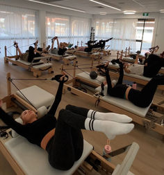 a group of people doing pivots in a room with lots of chairs and windows