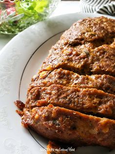 meatloaf on a white plate with flowers in the background