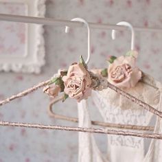 two pink roses are hanging from a clothes hanger