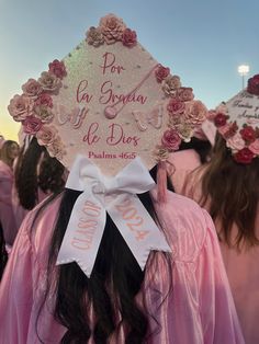 a group of women in pink gowns and hats with flowers on their heads are standing together