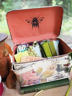 an open tin box filled with lots of items