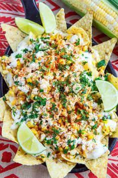 corn and cheese nachos on a plate with lime wedges