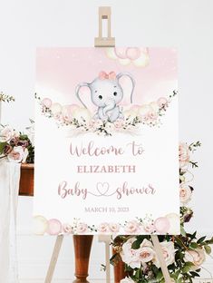 a welcome sign for a baby shower with pink flowers and an elephant on the front