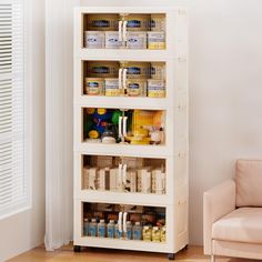 a white shelf filled with lots of food and condiments next to a chair