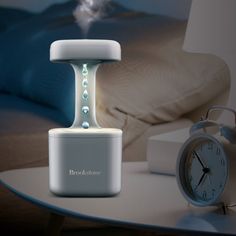 an alarm clock sitting on top of a table next to a night stand with water pouring out of it