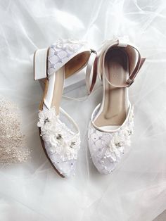 two pairs of white shoes with flowers on them