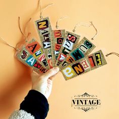 a person holding up some type of magnets with words on them and string attached to it