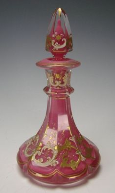 a pink and gold glass vase sitting on top of a table