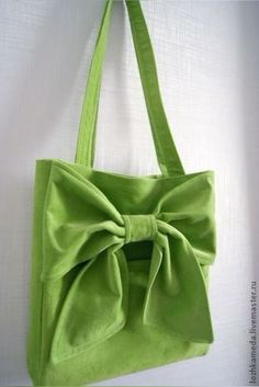 a green bag with a large bow on it