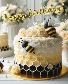 a birthday cake with two bees on top and flowers in the background that says happy birthday