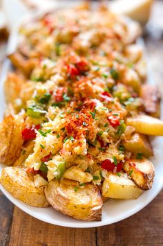 a white plate topped with potatoes covered in toppings