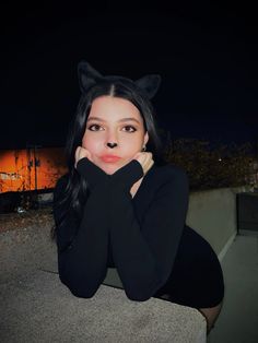 a woman with long black hair and cat ears on her head is posing for the camera