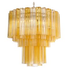 a chandelier made out of yellow glass tubes hanging from a chain on a white background