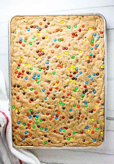 a cookie with colorful sprinkles on it and a towel next to it