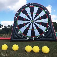 an inflatable dart set up on the ground with four yellow balls around it