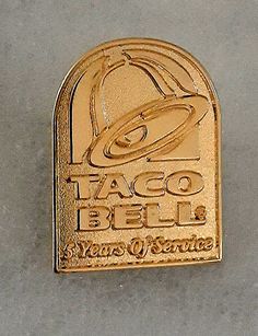 a close up of a metal object on a surface with a sign that says taco bell