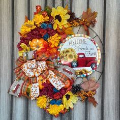 a wreath with sunflowers and fall leaves on it