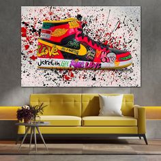 a living room with a couch and a painting on the wall that has a shoe painted on it