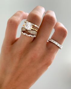 a woman's hand with three different rings on it