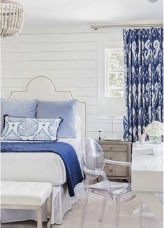 a bedroom with white walls and blue bedding