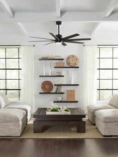 a living room with two couches and a coffee table in front of the ceiling fan