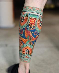 a man's leg with colorful tattoos on it