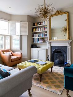 a living room filled with furniture and a fire place in front of a mirror on the wall