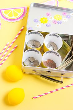 a tin filled with lots of money next to lemons