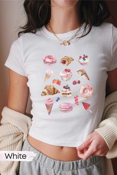 Step back into the nostalgia of the 90s and Y2K era with our adorable trendy baby tees or unisex oversized shirts adorned with a delightful pastry collage! Embrace the sweet vibes of balletcore and soft girl aesthetic with this unique Coquette Clothing creation, perfect for teenage girls or the neverageing and trendy adults  and anyone seeking a touch of vintage charm. Featuring a medley of cute pastries including croissants, donuts, ice cream cones, strawberries, cakes, cinnamon rolls, and macarons, this graphic shirt is a feast for the eyes. Whether you're shopping for your daughter, girlfriend, or simply treating yourself, our pastry-themed shirts make for the ideal gift, blending playful nostalgia with contemporary flair. Slip into this crop top and indulge in the sweetness of style! M Sweet Cartoon Print Short Sleeve Tops, Sweet Pink Tops With Cartoon Print, Sweet Cartoon Print Crew Neck Top, Sweet Pink T-shirt With Cartoon Print, Cute Funny Print T-shirt, Sweet Short Sleeve Tops With Funny Print, Sweet Tops With Funny Print And Crew Neck, Sweet White Tops With Cartoon Print, Sweet Short Sleeve Tops With Graphic Print