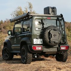 a green jeep parked on top of a dry grass field